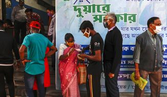 Indians wearing face masks as a precautionary measure against the coronavirus stand in a queue to apply for a health card initiated by West Bengal state government in Kolkata, India, Saturday, Jan. 2, 2021. (AP Photo/Bikas Das)