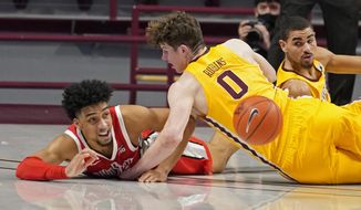 Ohio State&#39;s Justice Sueing, left, gets off a pass despite a collision with Minnesota&#39;s Liam Robbins in the first half of an NCAA college basketball game Sunday, Jan. 3, 2021, in Minneapolis. (AP Photo/Jim Mone)