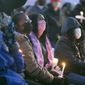 Toscha Flowers, center in pink scarf, the fiance of slain Rockford bowler Jerome Woodfork, sits in the front row and listens to speakers during a vigil at Don Carter Lanes for the six victims of a shooting that occurred there, Saturday, Jan. 2, 2021 in Rockford, Ill. (Scott P. Yates/Rockford Register Star via AP)