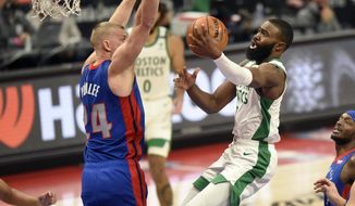 Boston Celtics guard Jaylen Brown, right, drives against Detroit Pistons center Mason Plumlee during the first half of an NBA basketball game Sunday, Jan. 3, 2021, in Detroit. (AP Photo/Jose Juarez)