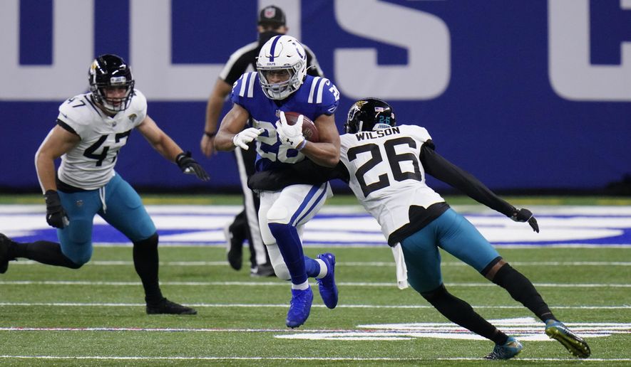 Indianapolis Colts&#39; Jonathan Taylor (28) runs past Jacksonville Jaguars&#39; Jarrod Wilson (26) during the first half of an NFL football game, Sunday, Jan. 3, 2021, in Indianapolis. (AP Photo/AJ Mast)
