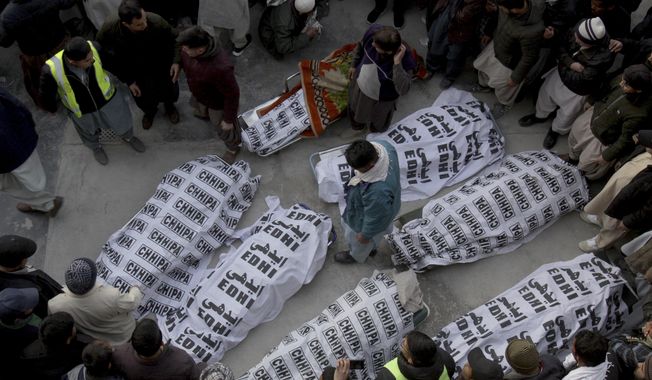 People from the Shiite Hazara community gather around the bodies of coal mine workers who were killed by unknown gunmen near the Machh coal field, in Quetta, Pakistan, Sunday, Jan. 3, 2021. Gunmen opened fire on a group of minority Shiite Hazara coal miners after abducting them, killing 11 in southwestern Baluchistan province early Sunday, a Pakistani official said. (AP Photo/Arshad Butt)