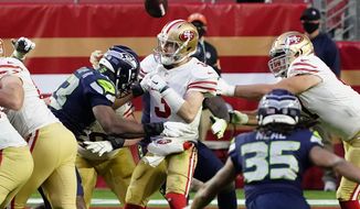 Seattle Seahawks defensive end Carlos Dunlap forces San Francisco 49ers quarterback C.J. Beathard (3) to fumble during the second half of an NFL football game, Sunday, Jan. 3, 2021, in Glendale, Ariz. (AP Photo/Rick Scuteri)