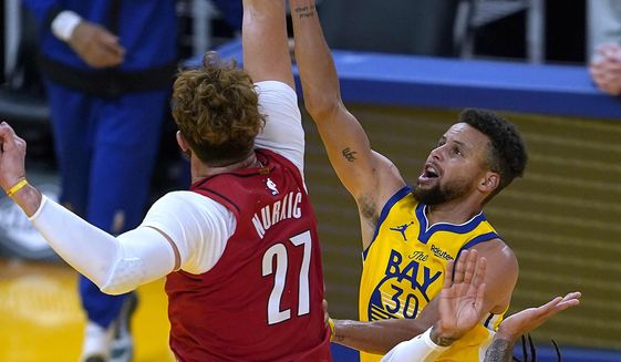 Golden State Warriors guard Stephen Curry (30) drives to the basket against Portland Trail Blazers center Jusuf Nurkic (27) and guard Gary Trent Jr. (2) during the first half of an NBA basketball game in San Francisco, Sunday, Jan. 3, 2021. (AP Photo/Tony Avelar)