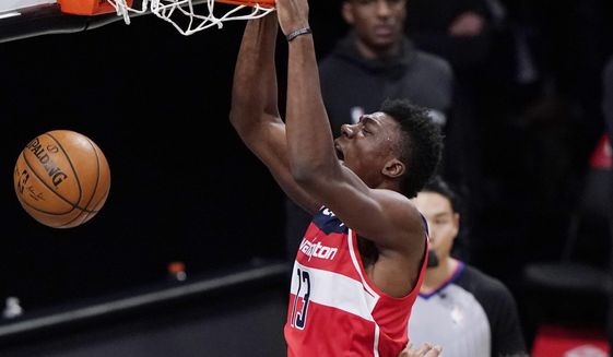 Washington Wizards center Thomas Bryant (13) dunks over Brooklyn Nets center Jarrett Allen (31) during the third quarter of an NBA basketball game, Sunday, Jan. 3, 2021, in New York. (AP Photo/Kathy Willens)