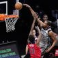 Brooklyn Nets forward Kevin Durant, right, dunks over Washington Wizards center Thomas Bryant, left, during the second quarter of an NBA basketball game, Sunday, Jan. 3, 2021, in New York. (AP Photo/Kathy Willens)