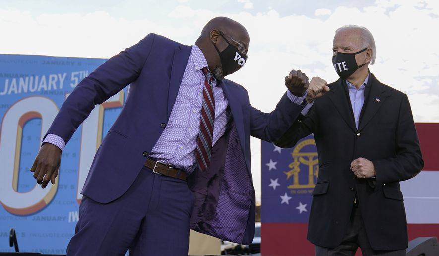 President-elect Joe Biden elbow bumps Senate candidate Raphael Warnock in Atlanta, Monday, Jan. 4, 2021, during a campaign rally for Warnock and Jon Ossoff. (AP Photo/Carolyn Kaster)