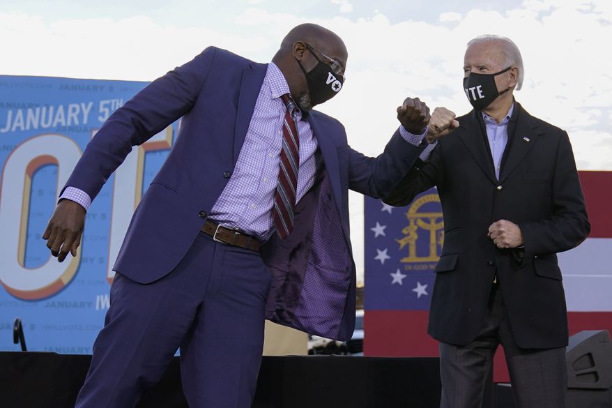 President-elect Joe Biden elbow bumps Senate candidate Raphael Warnock in Atlanta, Monday, Jan. 4, 2021, during a campaign rally for Warnock and Jon Ossoff. (AP Photo/Carolyn Kaster)