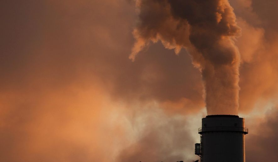 FILE - The Jan. 10, 2009 file photo shows a flock of geese flying past a smokestack at the Jeffery Energy Center coal power plant near Emmitt, Kan. A new study says the amount of global warming already baked into the air because of past carbon pollution is enough to blow past internationally agreed upon climate limits. A study on Monday, Jan. 4, 2021 takes a different look at what's called committed warming that comes from heat-trapping gases staying in the atmosphere for more than a century. (AP Photo/Charlie Riedel, File)