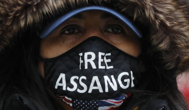 A Julian Assange supporter wears a face mask bearing his name outside the Old Bailey in London, Monday, Jan. 4, 2021. (AP Photo/Frank Augstein)
