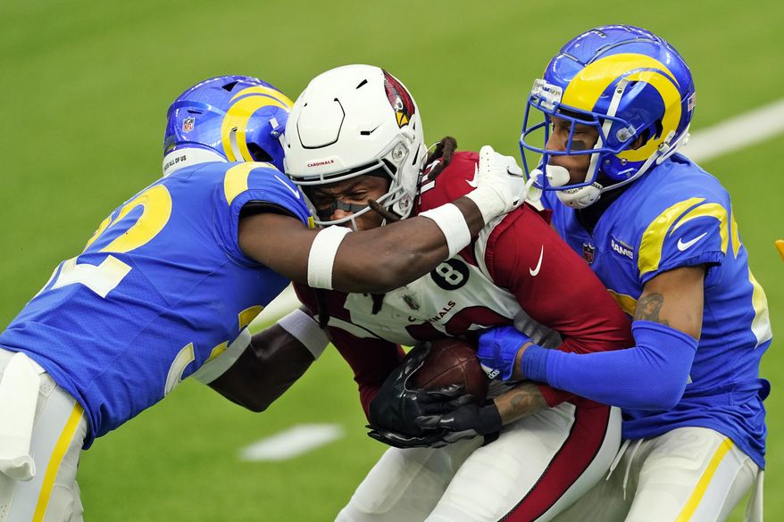 Arizona Cardinals wide receiver DeAndre Hopkins, center, is tackled by Los Angeles Rams strong safety Jordan Fuller, left, and cornerback Troy Hill during the first half of an NFL football game Sunday, Jan. 3, 2021, in Inglewood, Calif. (AP Photo/Ashley Landis)
