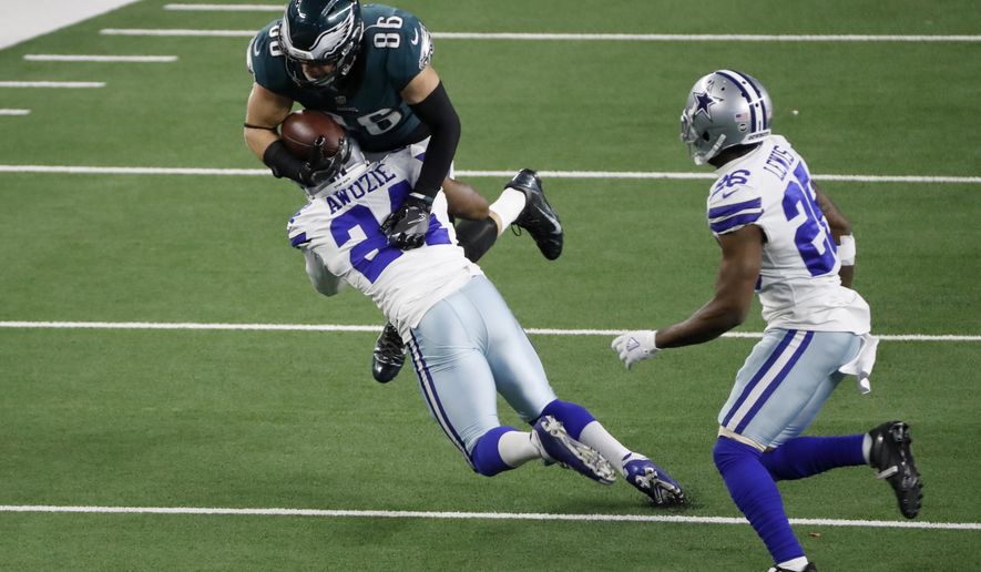 Dallas Cowboys cornerback Chidobe Awuzie (24) stops Philadelphia Eagles tight end Zach Ertz (86) from gaining extra yardage after a catch as cornerback Jourdan Lewis (26) looks on in the second half of an NFL football game in Arlington, Texas, Sunday, Dec. 27. 2020. (AP Photo/Roger Steinman)