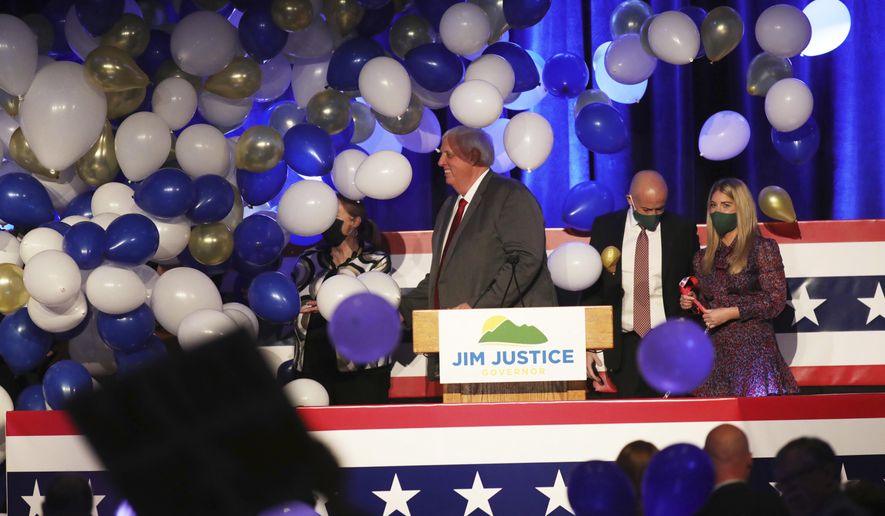 West Virginia Gov. Jim Justice, center, celebrates his reelection at The Greenbrier Resort, Tuesday, Nov. 3, 2020, in White Sulphur Springs, W.Va. (AP Photo/Chris Jackson)