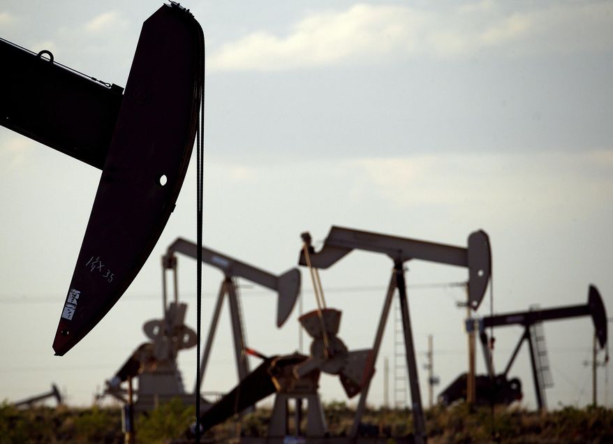 In this April 24, 2015, photo, pumpjacks work in a field near Lovington, N.M. Oil and gas development infused $2.8 billion into New Mexico coffers during the 2020 fiscal year and marked its second-highest total revenue ever reported despite a global price war and plummeting demand amid the coronavirus pandemic, according to a report released Monday, Dec. 21, 2020. (AP Photo/Charlie Riedel) **FILE**