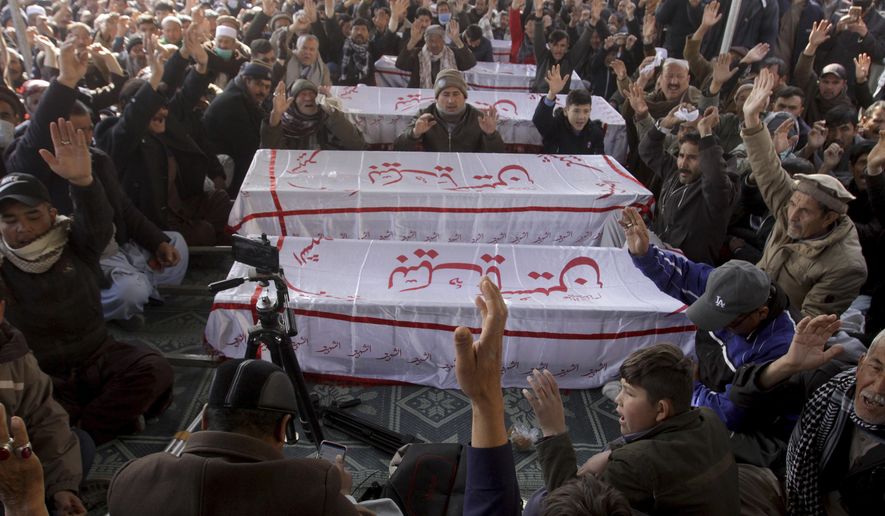 People from the Shiite Hazara community chant slogans beside caskets of coal mine workers who were killed by unknown gunmen near the Machh coal field, during a sit-in protest, in Quetta, Pakistan, Monday, Jan. 4, 2021. Gunmen opened fire on a group of minority Shiite Hazara coal miners after abducting them, killing 11 in southwestern Baluchistan province early Sunday, a Pakistani official said. (AP Photo/Arshad Butt)