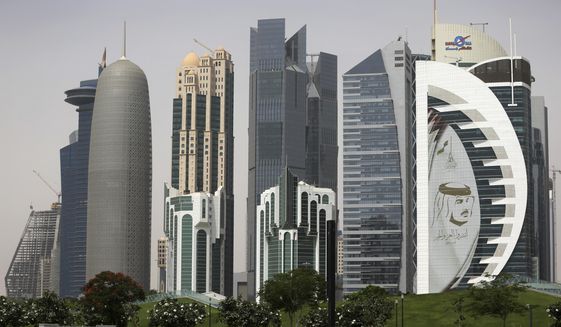 In this May 5, 2018, file photo, a giant image of the Emir of Qatar Sheikh Tamim bin Hamad Al Thani adorns a tower in Doha, Qatar. Kuwait’s foreign ministry announced Monday, Jan. 4, 2021, that Saudi Arabia will open its air and land borders with Qatar in the first steps toward ending a diplomatic crisis that has deeply divided regional U.S. allies since 2017. (AP Photo/Kamran Jebreili)
