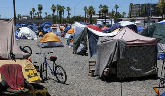 In this Wednesday, Aug. 5, 2020, file photo, a large homeless encampment is shown in Phoenix. Agencies that help the homeless in Arizona&#39;s largest county say the annual January count of people living on the streets has been canceled because of concerns about viral spread during the coronavirus pandemic. (AP Photo/Ross D. Franklin) ***FILE**