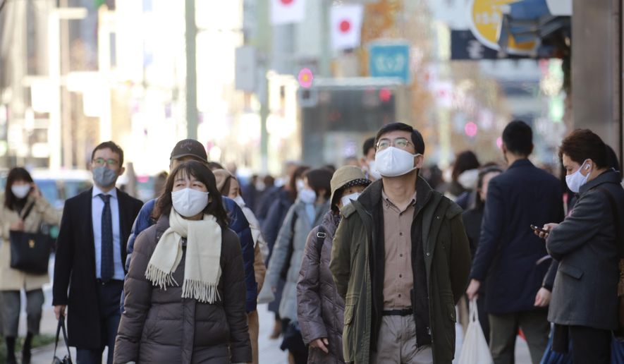People wearing face masks to protect against the spread of the coronavirus walk at Ginza shopping street in Tokyo, Monday, Jan. 4. 2021. (AP Photo/Koji Sasahara)