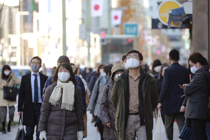 People wearing face masks to protect against the spread of the coronavirus walk at Ginza shopping street in Tokyo, Monday, Jan. 4. 2021. (AP Photo/Koji Sasahara)