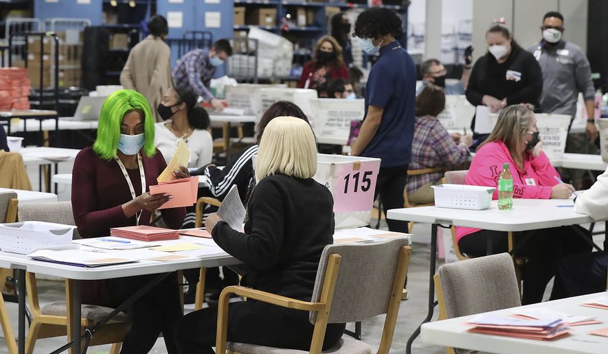 Election workers sort provisional ballots during a flurry of activity on election night at the Beauty P. Baldwin Voter Registrations and Elections Building, Tuesday, Jan. 5, 2021, in Lawrenceville, Ga. (Curtis Compton/Atlanta Journal-Constitution via AP)