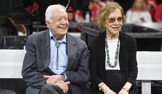 FILE- In this Sept. 30, 2018 file photo, former President Jimmy Carter and Rosalynn Carter are seen ahead of an NFL football game between the Atlanta Falcons and the Cincinnati Bengals, in Atlanta.  Former President Jimmy Carter and former first lady Rosalynn Carter will not attend President-elect Joe Biden’s inauguration. It marks the first time the couple, 96 and 93, will have missed the ceremonies since Carter was sworn-in as the 39th president in 1977.(AP Photo/John Amis, File)