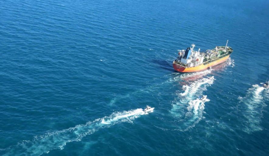 In this photo released Monday, Jan. 4, 2021, by Tasnim News Agency, the MT Hankuk Chemi, a South Korean-flagged tanker is escorted by Iranian Revolutionary Guard boats on the Persian Gulf. Iranian state television acknowledged that Tehran seized the oil tanker in the Strait of Hormuz. The report on Monday alleged the MT Hankuk Chemi had been stopped by Iranian authorities over alleged “oil pollution” in the Persian Gulf and the strait. (Tasnim News Agency via AP)