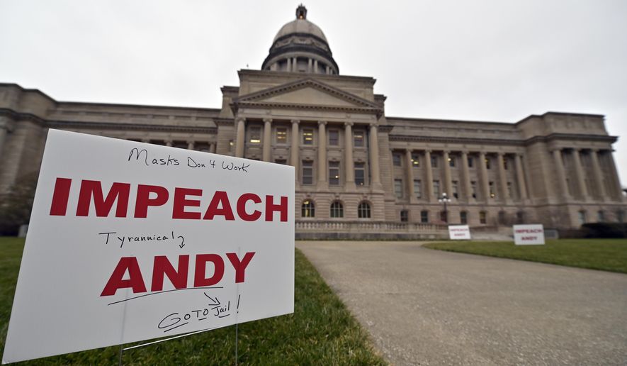 Signs, some with personal messages promoting the impeachment of Kentucky Governor Andy Beshear line the walkway and lawn of the State Capitol building in Frankfort, Ky., Tuesday, Jan. 5, 2021. (AP Photo/Timothy D. Easley)