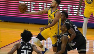 Golden State Warriors guard Stephen Curry, center, shoots against the Sacramento Kings during the first half of an NBA basketball game in San Francisco, Monday, Jan. 4, 2021. (AP Photo/Jeff Chiu)