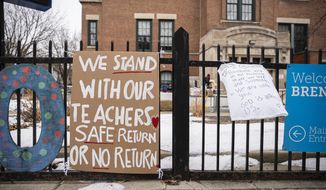 Banners in support of the elementary school teachers hang outside Brentano Elementary School as teachers instruct virtual classes during a protest against returning to in-person teaching outside of Brentano Elementary School in Chicago, Monday, Jan. 4, 2021. (Anthony Vazquez/Chicago Sun-Times via AP)