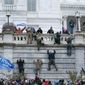 Supporters of President Donald Trump climb the west wall of the the U.S. Capitol on Wednesday, Jan. 6, 2021, in Washington. (AP Photo/Jose Luis Magana)