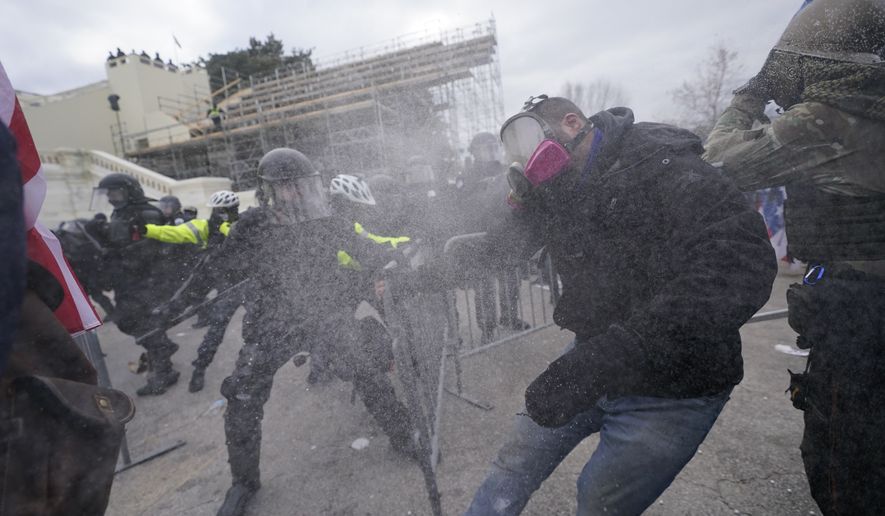 Trump supporters try to break through a police barrier, Wednesday, Jan. 6, 2021, at the Capitol in Washington. As Congress prepares to affirm President-elect Joe Biden's victory, thousands of people have gathered to show their support for President Donald Trump and his claims of election fraud. (AP Photo/Julio Cortez)
