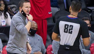 Washington Wizards head coach Scott Brooks, left, reacts to referee Suyash Mehta, right, during the second half of an NBA basketball game against the Philadelphia 76ers, Wednesday, Jan. 6, 2021, in Philadelphia. The 76ers won 141-136. (AP Photo/Chris Szagola)