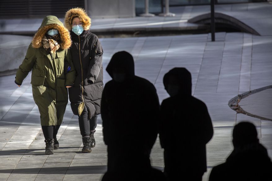 People wearing face masks to protect against the coronavirus walk on an unseasonably cold day at an office and shopping complex in Beijing, Wednesday, Jan. 6, 2021. China&#39;s Hebei province is enforcing stricter control measures following a further rise in coronavirus cases in the province, which is adjacent to the capital Beijing and is due to host events for next year&#39;s Winter Olympics. (AP Photo/Mark Schiefelbein)