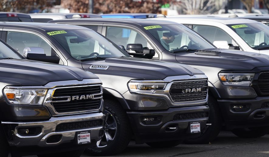 A long row of unsold 2020 pickup trucks sits at a Ram dealership Sunday, Dec. 27, 2020, in Littleton, Colo.  A new government report says gas mileage for new vehicles dropped and pollution increased in model year 2019 for the first time in five years.  (AP Photo/David Zalubowski)