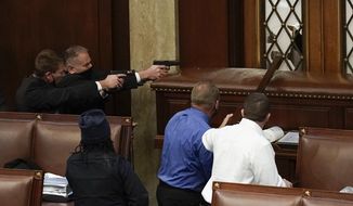 U.S. Capitol Police with guns drawn watch as protesters try to break into the House Chamber at the U.S. Capitol on Wednesday, Jan. 6, 2021, in Washington. (AP Photo/J. Scott Applewhite)