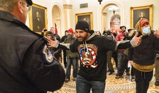 Supporters of President Donald Trump are confronted by Capitol Police officers outside the Senate Chamber at the Capitol, Wednesday, Jan. 6, 2021 in Washington. (AP Photo/Manuel Balce Ceneta)