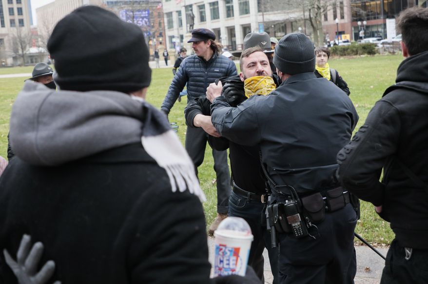 Law enforcement personnel restrain a member of the Proud Boys as a fight breaks out during a "Stop the Steal" rally on Wednesday, Jan. 6, 2021, at the Ohio Statehouse in Columbus, Ohio. Hundreds of supporters of President Donald Trump came to the Statehouse to protest the congressional certification of Democratic President-elect Joe Biden. (Joshua A. Bickel/The Columbus Dispatch via AP)