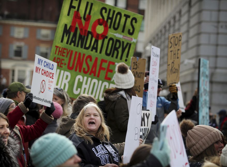 Demonstrators rally outside the Massachusetts State House, protesting Governor Charlie Baker's order for mandatory influenza vaccinations for students in Boston on Wednesday, Jan. 6, 2021. (Craig F. Walker/The Boston Globe via AP)