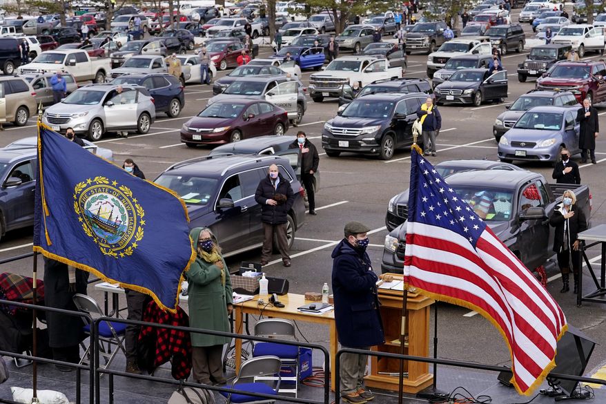 New Hampshire. State Representatives stand for the Pledge of Allegiance during an outdoor meeting of the New Hampshire House of Representatives in a parking lot, due to the COVID-19 virus outbreak, at the University of New Hampshire Wednesday, Jan. 6, 2021, in Durham, N.H. (AP Photo/Charles Krupa)