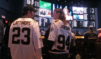 Football fans wait for kickoff in the sports betting lounge at the Ocean Casino Resort on Sept. 9, 2018,  in Atlantic City, N.J. On Wednesday, Jan. 6, 2021, New York&#39;s governor did an about-face and embraced mobile sports betting as a way to deal with financial losses from the coronavirus pandemic, and a company that tracks gambling legislation and performance predicted revenue from legal sports betting could reach $3.1 billion in 2021 and as much as $10 billion within five years. (AP Photo/Wayne Parry)