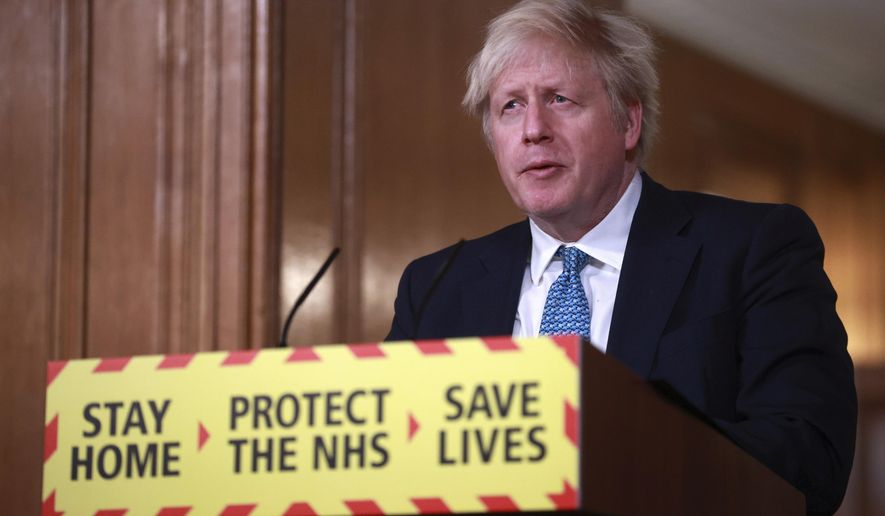 Britain&#39;s Prime Minister Boris Johnson speaks during a news conference in response to the ongoing situation with the coronavirus (COVID-19) pandemic, inside 10 Downing Street in London, Tuesday, Jan. 5, 2021. England is entering a third national lockdown that will last at least six weeks, as authorities struggle to stem a surge in COVID-19 infections that threatens to overwhelm hospitals around the U.K. (Hannah McKay/Pool photo via AP)
