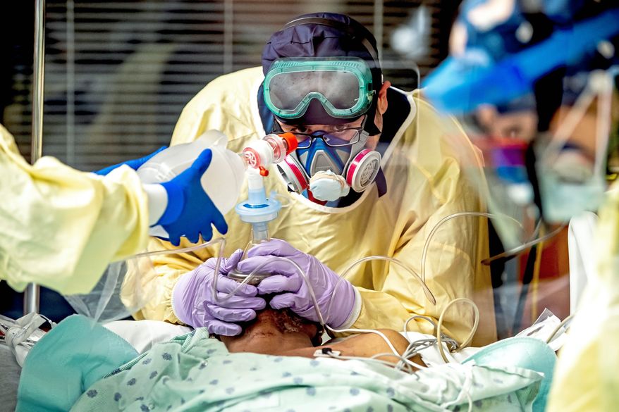 Walter Smith, a respiratory therapist, gives oxygen to a COVID-19 patient before intubating him shortly after he was transferred to the intensive care unit from the main ward for COVID-19 patients at Uniontown Hospital, Wednesday, Dec.16, 2020, in Uniontown, Pa. The hospital is at capacity with about half of its beds, including all 15 beds in the ICU, being taken up by patients who are positive for COVID-19. (Alexandra Wimley/Pittsburgh Post-Gazette via AP)