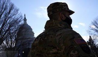 With the U.S. Capitol in the background, a member of the District of Columbia National Guard stands near newly-placed fencing around the Capitol grounds the day after violent protesters loyal to President Donald Trump stormed the U.S. Congress in Washington, Thursday, Jan. 7, 2021. (AP Photo/Matt Slocum)