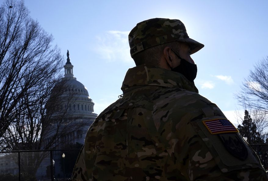 With the U.S. Capitol in the background, a member of the District of Columbia National Guard stands near newly-placed fencing around the Capitol grounds the day after violent protesters loyal to President Donald Trump stormed the U.S. Congress in Washington, Thursday, Jan. 7, 2021. (AP Photo/Matt Slocum)