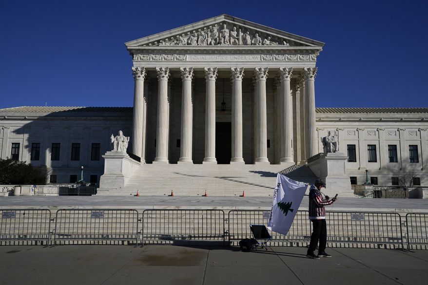 A person walks by newly-placed barricades around the Supreme Court Building, the day after violent protesters loyal to President Donald Trump stormed the U.S. Congress in Washington, Thursday, Jan. 7, 2021. (AP Photo/Evan Vucci)