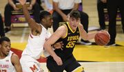 Iowa center Luka Garza (55) dribbles next to Maryland forward Jairus Hamilton, left, during the first half of an NCAA college basketball game, Thursday, Jan. 7, 2021, in College Park, Md. (AP Photo/Nick Wass)
