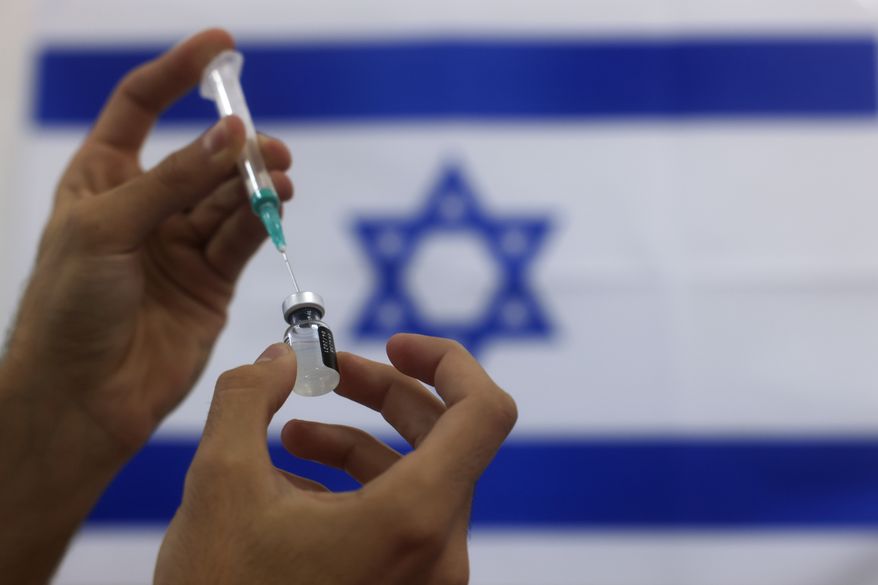 An Israeli military paramedic prepares a Pfizer COVID-19 vaccine, to be administered to elderly people at a medical center in Ashdod, southern Israel, Thursday, Jan. 7, 2021. (AP Photo/Tsafrir Abayov) **FILE**