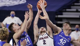 Gonzaga forward Drew Timme (2) grabs a rebound between BYU guard Connor Harding (44) and center Richard Harward (42) during the first half of an NCAA college basketball game in Spokane, Wash., Thursday, Jan. 7, 2021. (AP Photo/Young Kwak)