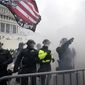 Police hold off Trump supporters who tried to break through a police barrier, Wednesday, Jan. 6, 2021, at the Capitol in Washington. As Congress prepares to affirm President-elect Joe Biden's victory, thousands of people have gathered to show their support for President Donald Trump and his claims of election fraud. (AP Photo/Julio Cortez)