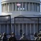 With the U.S. Capitol in the background, members of the National Guard stand behind newly placed fencing around the Capitol grounds the day after violent protesters loyal to President Donald Trump stormed the U.S. Congress in Washington, Thursday, Jan. 7, 2021. (AP Photo/Evan Vucci)